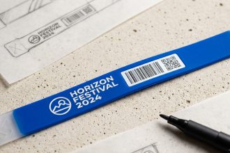 Bracelet événementiel personnalisé avec logo imprimé, nom de l'événement et QR code sur fond béton
