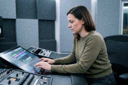 Designer sonore travaillant sur l'identité sonore d'une marque dans un studio d'enregistrement professionnel avec interface waveform