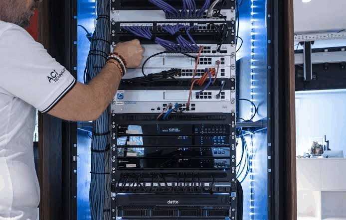 Technicien ACI Technology intervenant sur une baie informatique