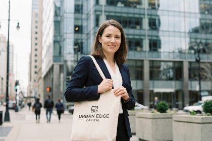 Femme professionnelle tenant un sac publicitaire personnalisé devant un bâtiment de bureaux moderne