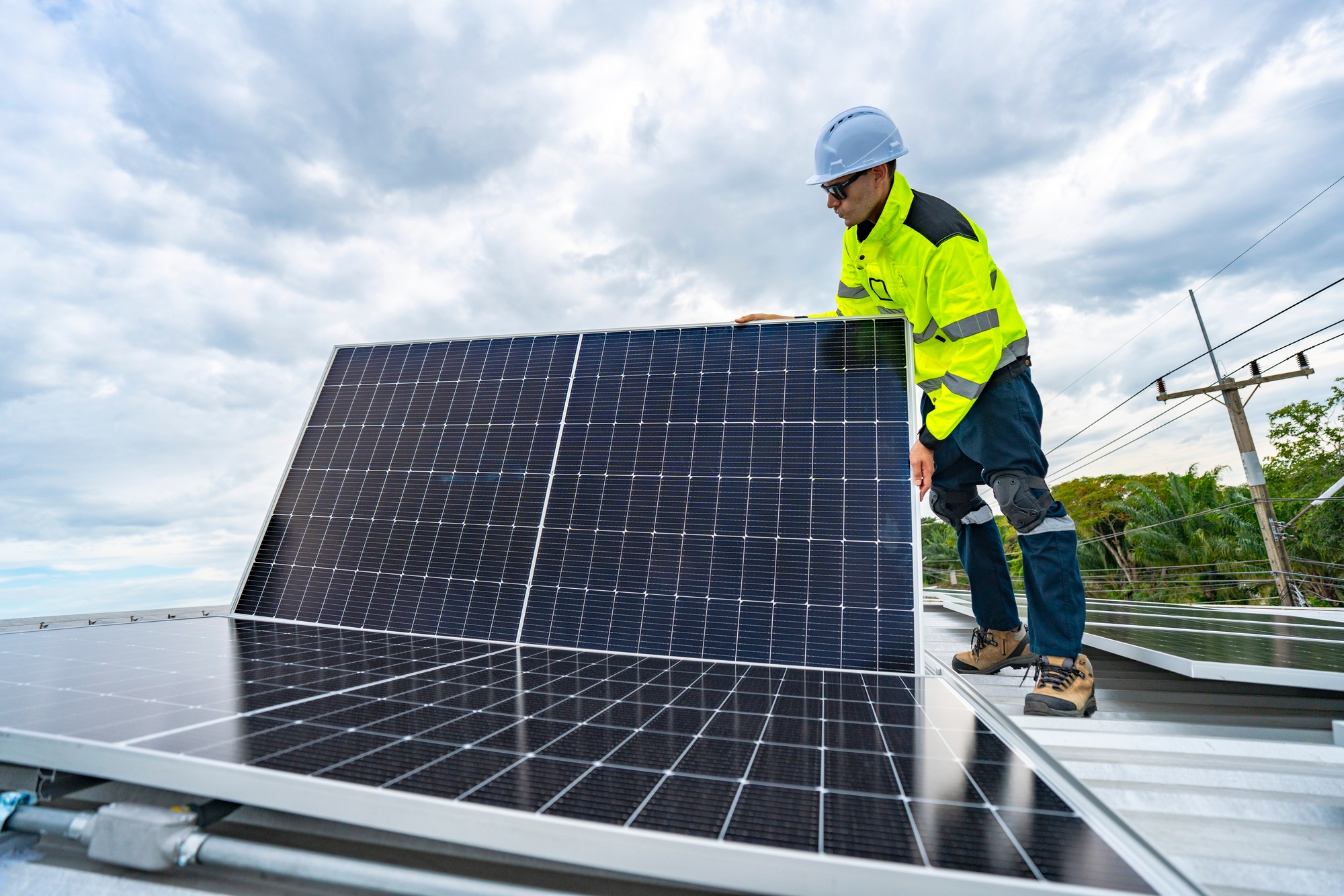 technician adjusts a solar panel on rooftop, emphasizing the transition to sustainable energy.
